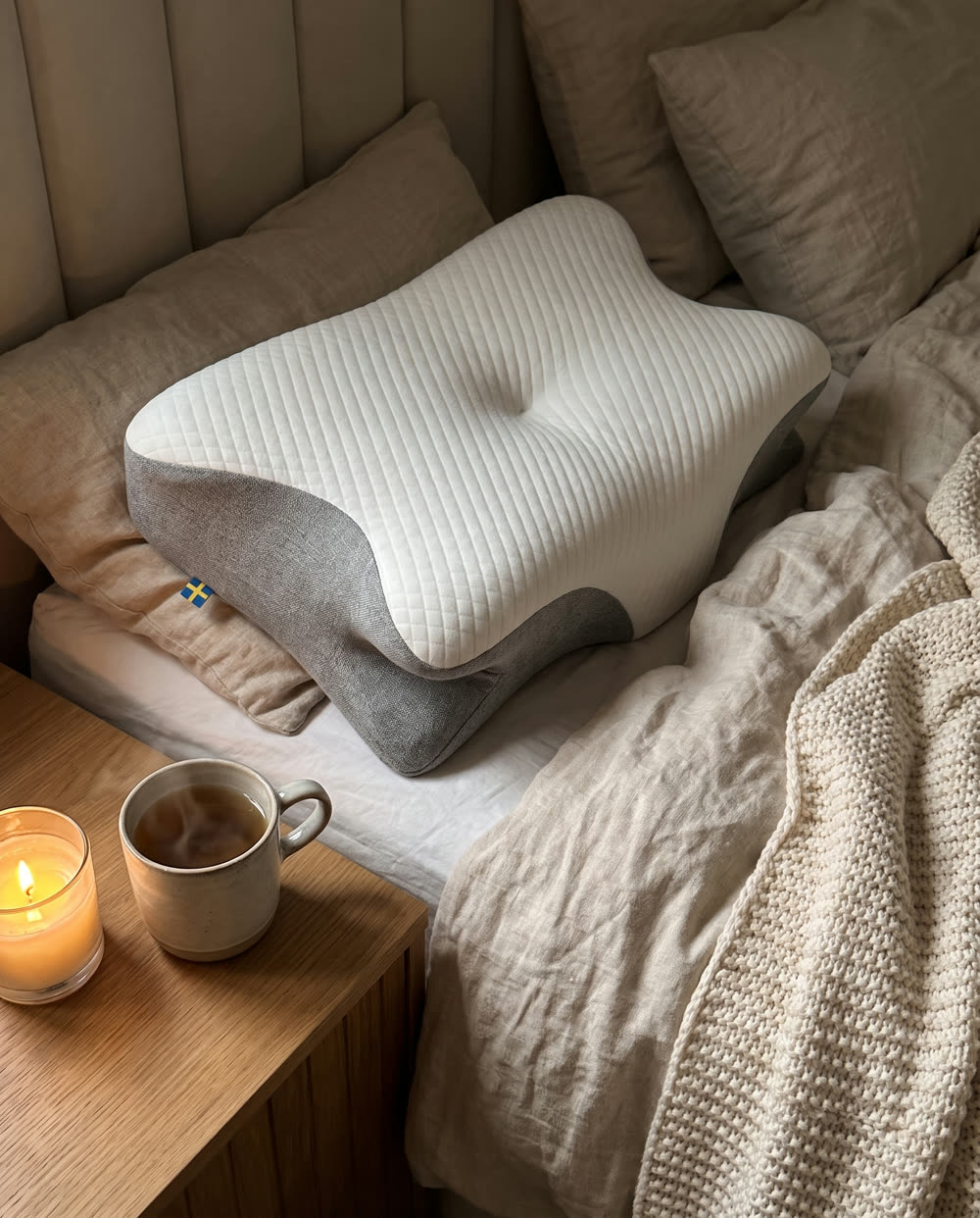 SleepEase sovkudde på säng med stickad pläd och te på nattduksbordet
