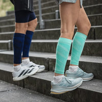 Två personer i Run Performance Compression Sleeves i marinblått och mint går i en trappa