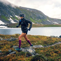 Löpare i fjällterräng med vinröda Bauerfeind Run Ultralight kompressionsstrumpor