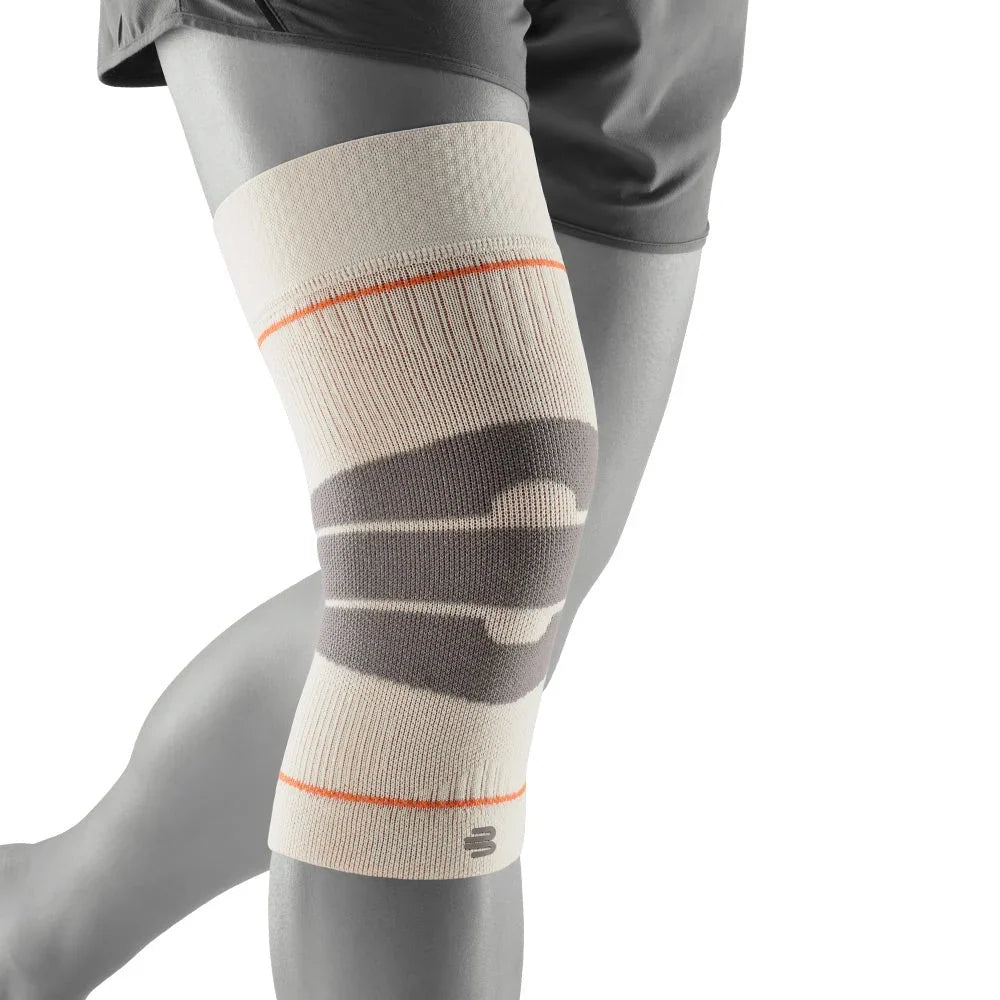 Bauerfeind Sports Outdoor Compression Knee Support i sandsten med grå och orange detaljer, sett snett framifrån