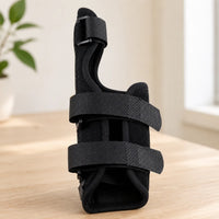 Handledsstöd med tumstöd och justerbara kardborreband för stabilisering av handled och tumme.